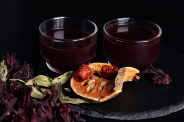 Herbal okra juice in transparent glass on black background.
