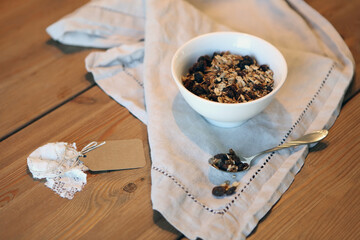whole wheat grains flake on wooden table. Homemade granola in a bowl on rustic wooden background