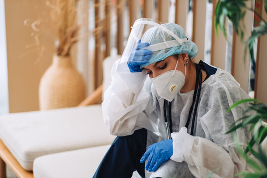 Fatigued woman nurse hospital worker surgeon doctor in protective wear looking sadness after hard working day or surgery. 