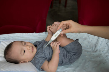 Asian baby boy measuring fever