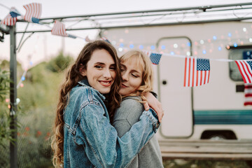 Dos chicas jovenes celebrando día de la independencia de estados unidos con barbacoa frente a una...