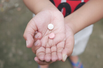 close up of medical pills on palm of child hand 