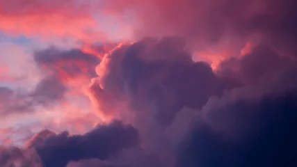 Foto op Canvas Magenta en blauw contrasteren met intense levendige dramatische wolkenlandschap met wolken verlicht in verschillende tinten tegen brandende zonsondergang. Klimaat en weersomstandigheden achtergrond concept. Behang. © Maarten Zeehandelaar