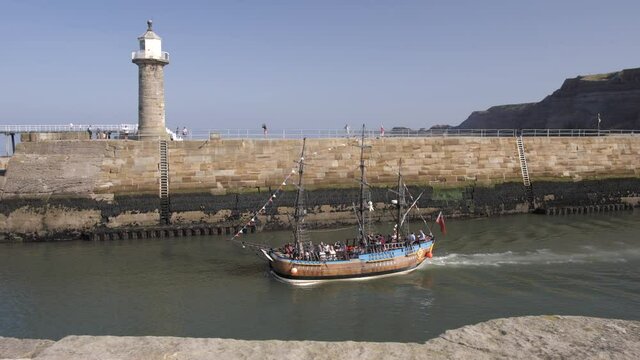 Tour boat on River Esk and lighthouse, Whitby, North Yorkshire, England, United Kingdom, Europe