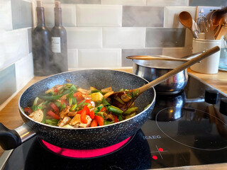 vegan stir fry with tofu being prepared in a wok