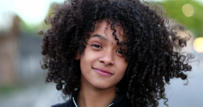Happy Brazilian child smiling at camera. Hispanic black girl kid with curly hair