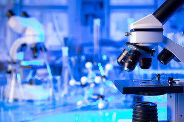 Coronavirus pandemic theme. Science research concerning fast covid tests and anti-covid vaccine. Microscope, beakers and test tubes in the scientific laboratory.