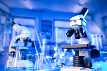 Coronavirus pandemic theme. Science research concerning fast covid tests and anti-covid vaccine. Microscope, beakers and test tubes in the scientific laboratory.