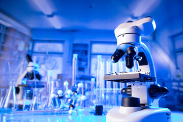 Coronavirus pandemic theme. Science research concerning fast covid tests and anti-covid vaccine. Microscope, beakers and test tubes in the scientific laboratory.