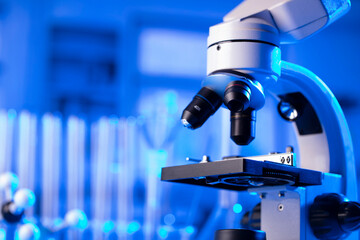 Coronavirus pandemic theme. Science research concerning fast covid tests and anti-covid vaccine. Microscope, beakers and test tubes in the scientific laboratory.