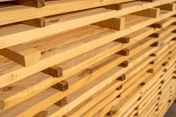 Storage of piles of wooden boards on the sawmill. Boards are stacked in a carpentry shop. Sawing drying and marketing of wood. Pine lumber for furniture production, construction. Lumber Industry.