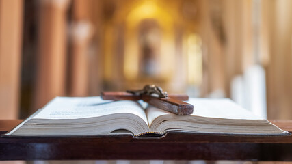Wooden Christian cross on Bible in the public church.
