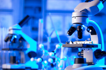 Coronavirus pandemic theme. Science research concerning fast covid tests and anti-covid vaccine. Microscope, beakers and test tubes in the scientific laboratory.