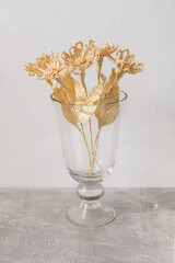 A glass vase with a bouquet of flowers made from straw on a white background