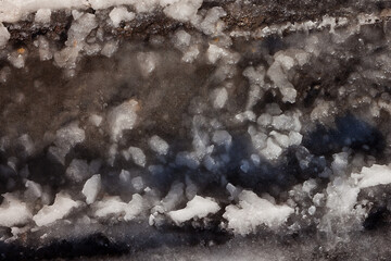 Snow in a frozen puddle. Close-up