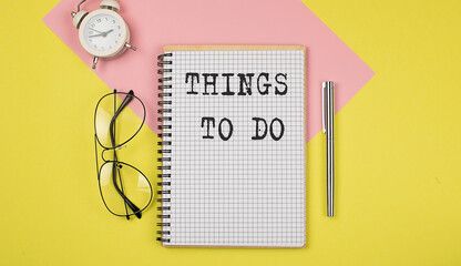 THINGS TO DO Notice on the notepad with pen, glasses and alarm clock