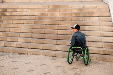 a young disabled person in a wheelchair can not enter the stairs. Accessible environment for the...