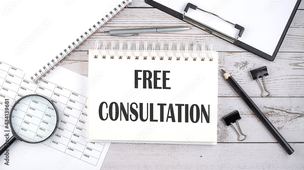Poster notepad with text free consultation with a pen,office tools and graphs on the desktop.