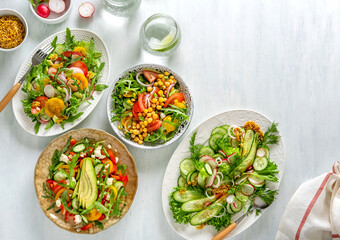 Various summer healthy vegetables salads with avocado, cucumber, radish, bell pepper and tomato. Healthy food.