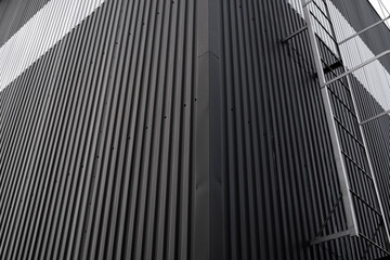 Black and white corrugated iron sheet used as a facade of a warehouse or factory. Texture of a seamless corrugated zinc sheet metal aluminum facade. Architecture. Metal texture.