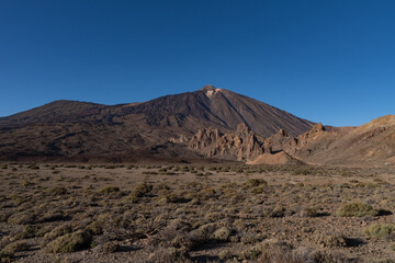 View of Roques de García unique rock formation with famous Pico del Teide mountain volcano summit in the background on a sunset, Teide National Park, Tenerife, Canary Islands, Spain