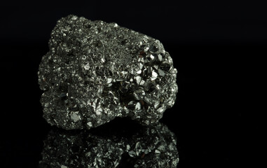 A cluster of pyrite crystals. Isolated on a black mirror background. - obrazy, fototapety, plakaty