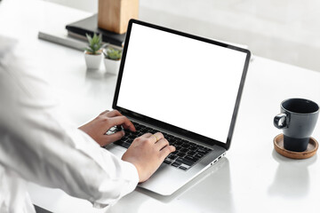 Back view of a businesswoman hand printing on a tablet with a blank white screen in the office. Mock up.
