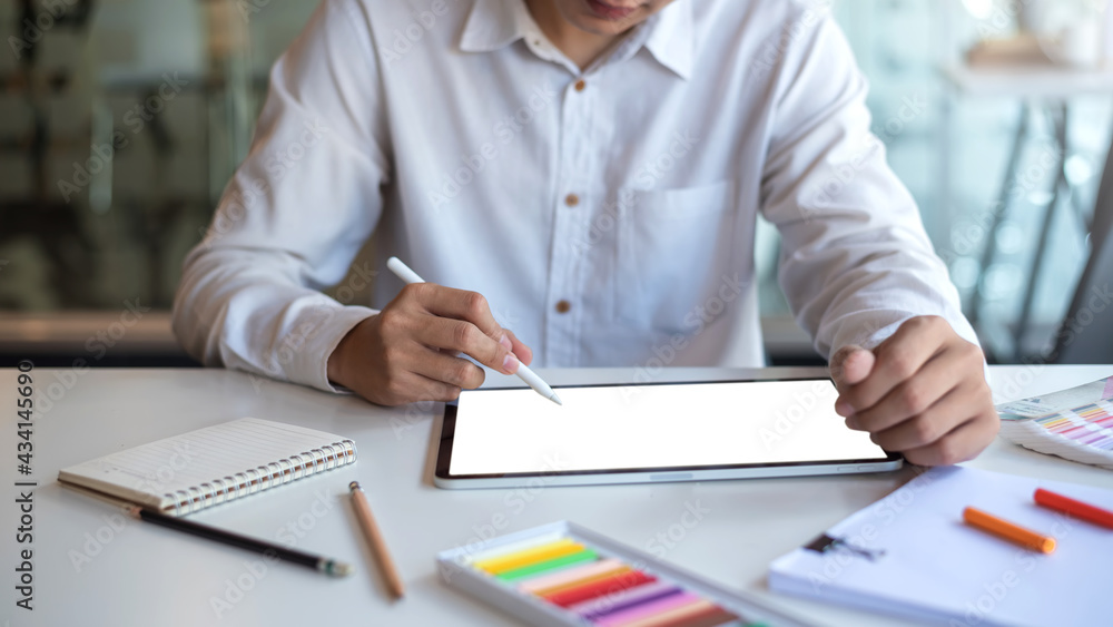 Poster image businessman designer working on a tablet with a blank white screen with a sample of color at t