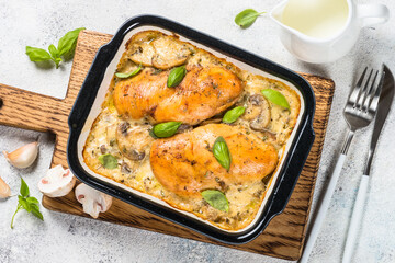 Baked chicken breast with mushrooms in cream sauce. Top view image with ingredients for cooking.
