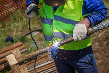 welding work man outdoors welding pipe mask