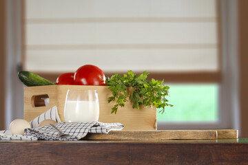Fresh vegetables on desk and window background 