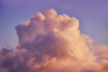 A large white cloud against a warm blue sunset sky
