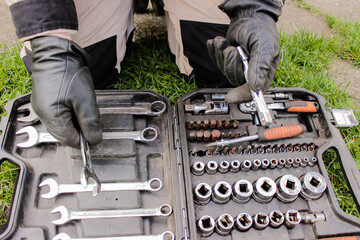 Male hand in construction of a glove with a ratchet taken from a toolbox. Industrial metal tool