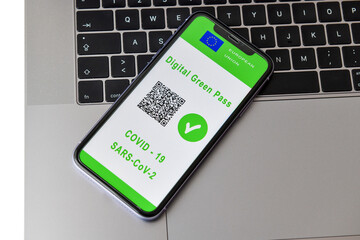 European Union digital green card with QR code on the mobile phone screen above the, passport. Immunity from Covid-19. Travel without restrictions