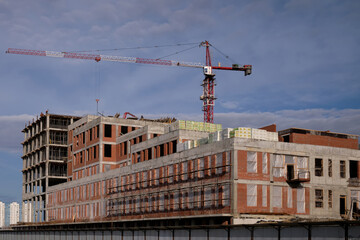 crane building of a multi-storey building. in the foreground of the floor.blue sky with big clouds