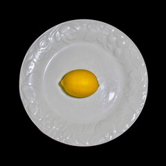 white ceramic plate with a lemon on a black background. Square format