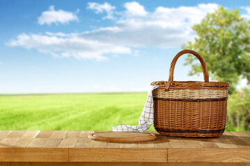 Wooden picnic basket of free space and summer landscape.  - obrazy, fototapety, plakaty