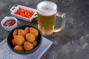 Traditional Brazilian fried snack stuffed with chicken and a glass of beer. Coxinha