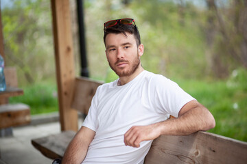 Handsome guy sitting on a park bench