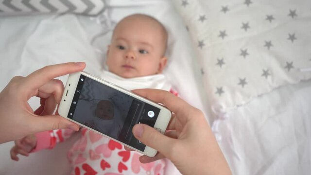 Mom takes pictures of her newborn daughter on the phone