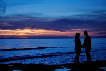 Romantic couple walking on the beach. Have a romantic date. Anniversary celebration. Valentine's Day. Birthday date. Knight and lady. Manners. Treat the loved one. Heart shaped sun