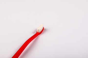 Red plastic toothbrush on a white background. Copy space