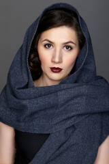 Beauty portrait of brunette woman dressed in dark blue scarf.