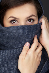 Beauty portrait of brunette woman dressed in dark blue scarf.