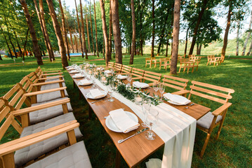 Wedding table with rustic decoration in the forest. Marriage celebration in the beautiful place.