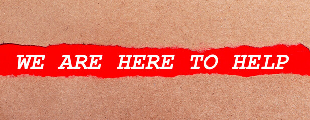 A strip of red paper under the torn brown paper. White lettering on red paper WE ARE HERE TO HELP....