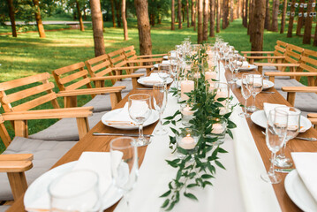 Rustic green branch and candles on the table. Wedding decoration.