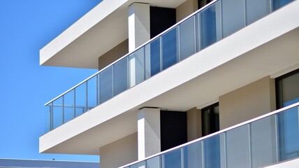 Fototapeta premium Condominium and apartment building with symmetrical modern architecture. Detail in modern residential flat apartment building exterior. Fragment of new luxury house and home complex. 