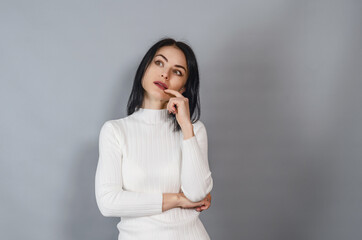 Pretty woman in a white sweater looks at the camera. Portrait of a successful businesswoman