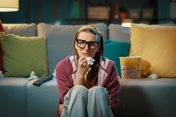 Obraz premium Emotional woman watching a romantic movie and crying